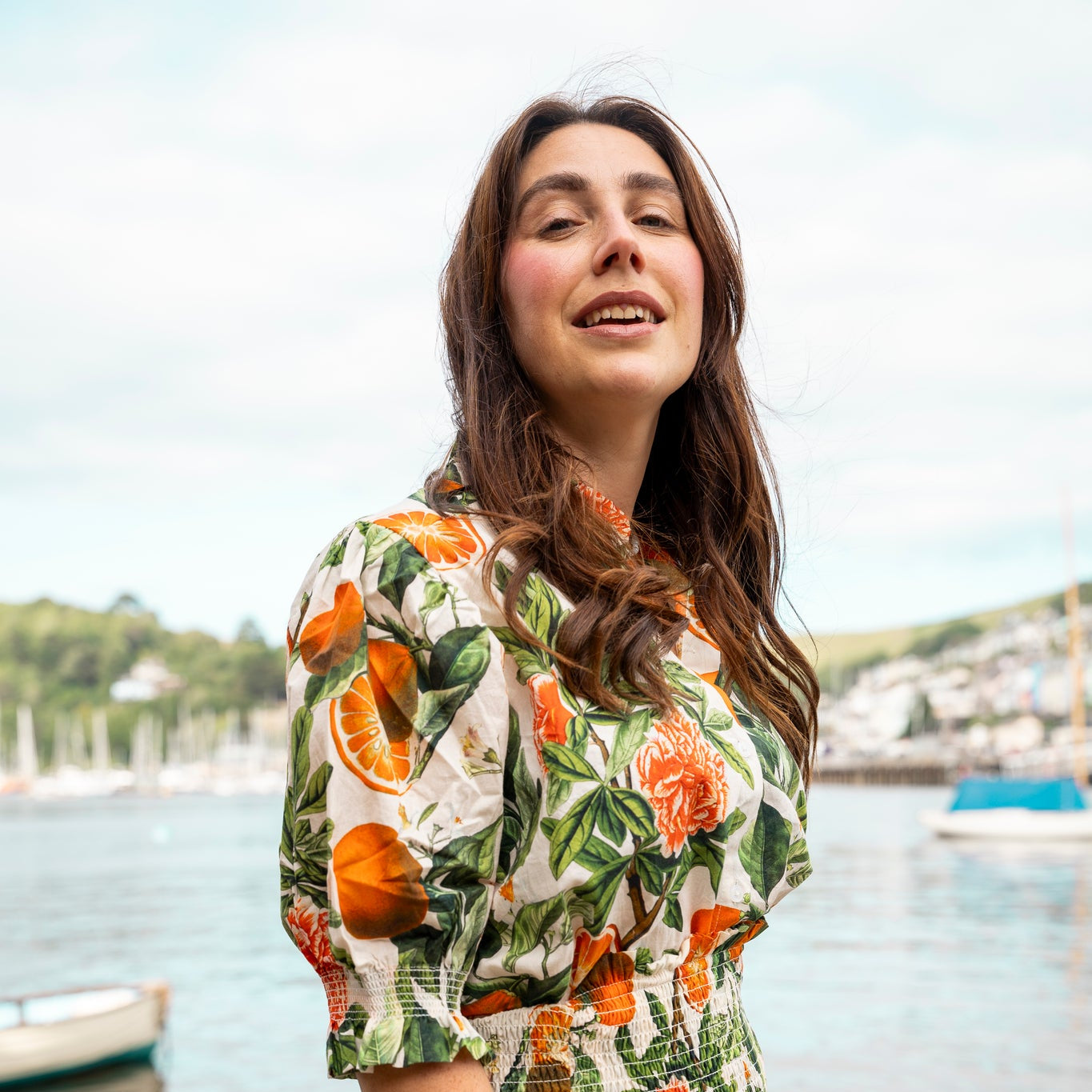 Rosehip Design Hannah Cotton Shirt in Blood Orange is a timeless blend of elegance and comfort. Made from soft cotton, it features a delicate frilled collar and intricate smocking on the sleeves for a touch of vintage charm. Designed for effortless styling, it pairs beautifully with the matching Bella Skirt.