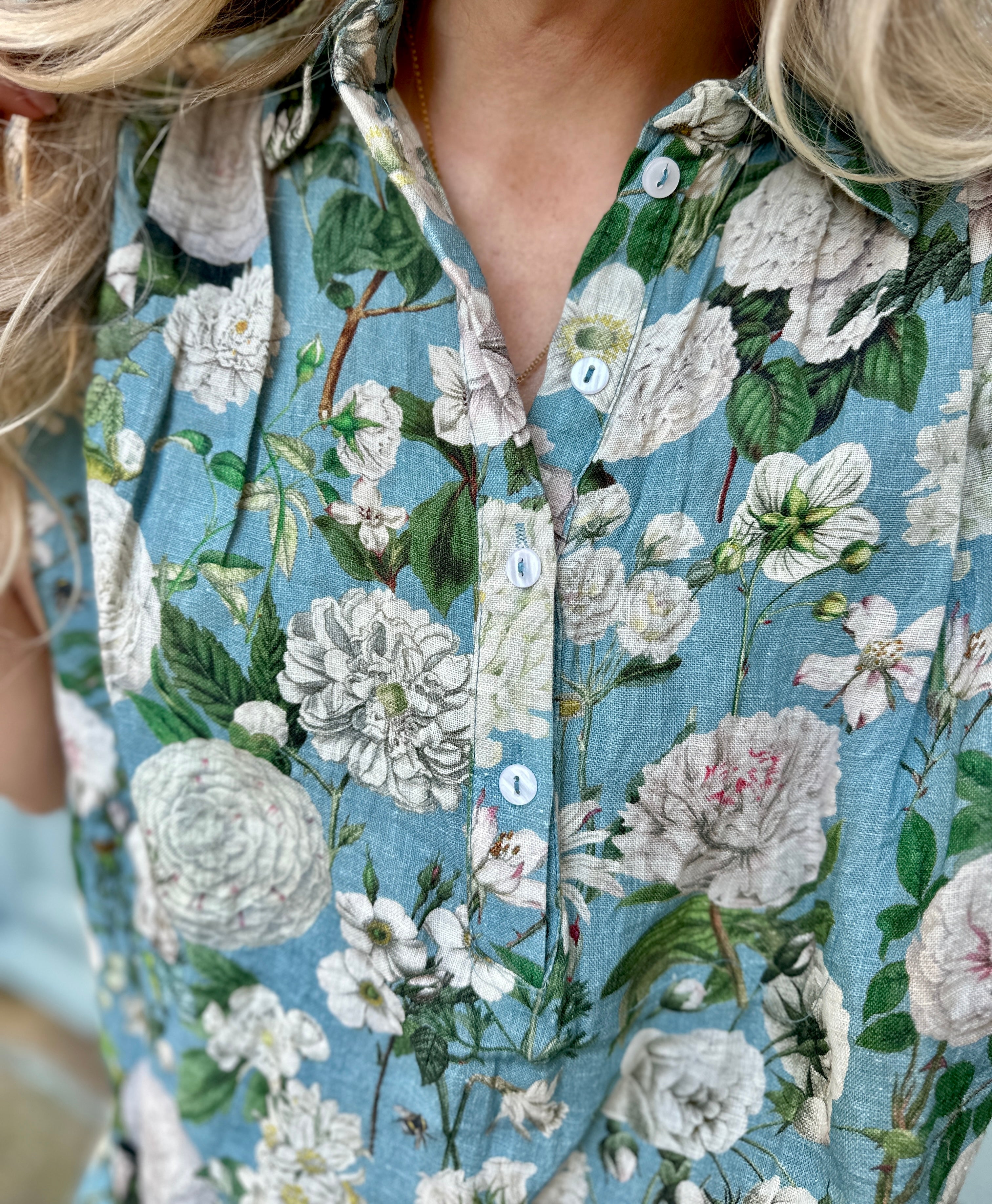 Light, breathable, and effortlessly stylish — the Jemma Shirt is made from 100% pure linen and finished with a white Camelia Ocean print on beautiful ocean coloured background. Designed with a neat collar, a partial button front, and gently capped sleeves, it&