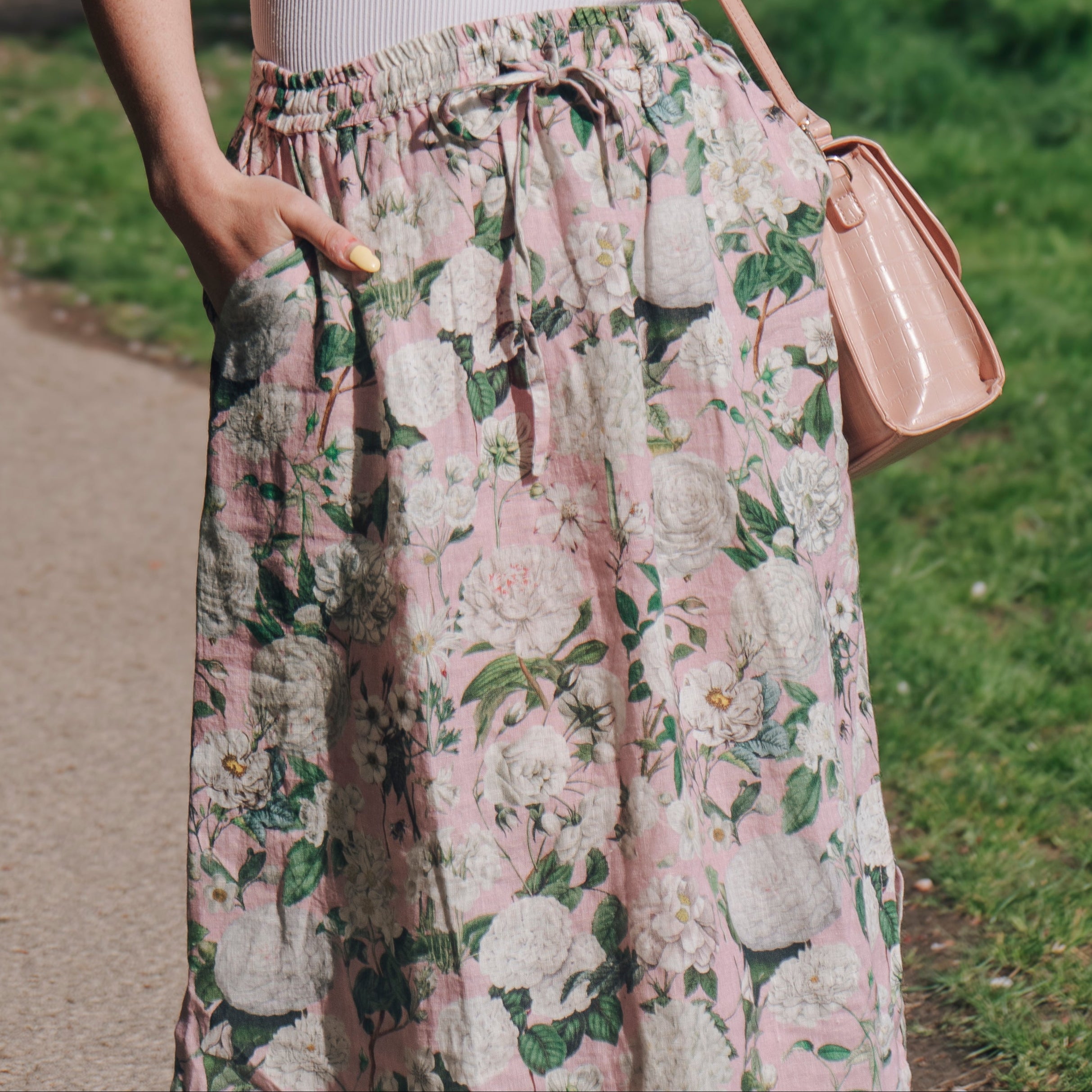 Crafted from 100% linen, the Rosehip Design Lilah Skirt in Camelia Rosepink design is a warm-weather staple with timeless appeal. Designed with a flattering classic cut, it features an elasticated waistband with a functional drawstring for a comfortable, adjustable fit. Subtle side slits add ease of movement and a touch of effortless elegance — perfect for sunny days, from morning markets to seaside strolls.