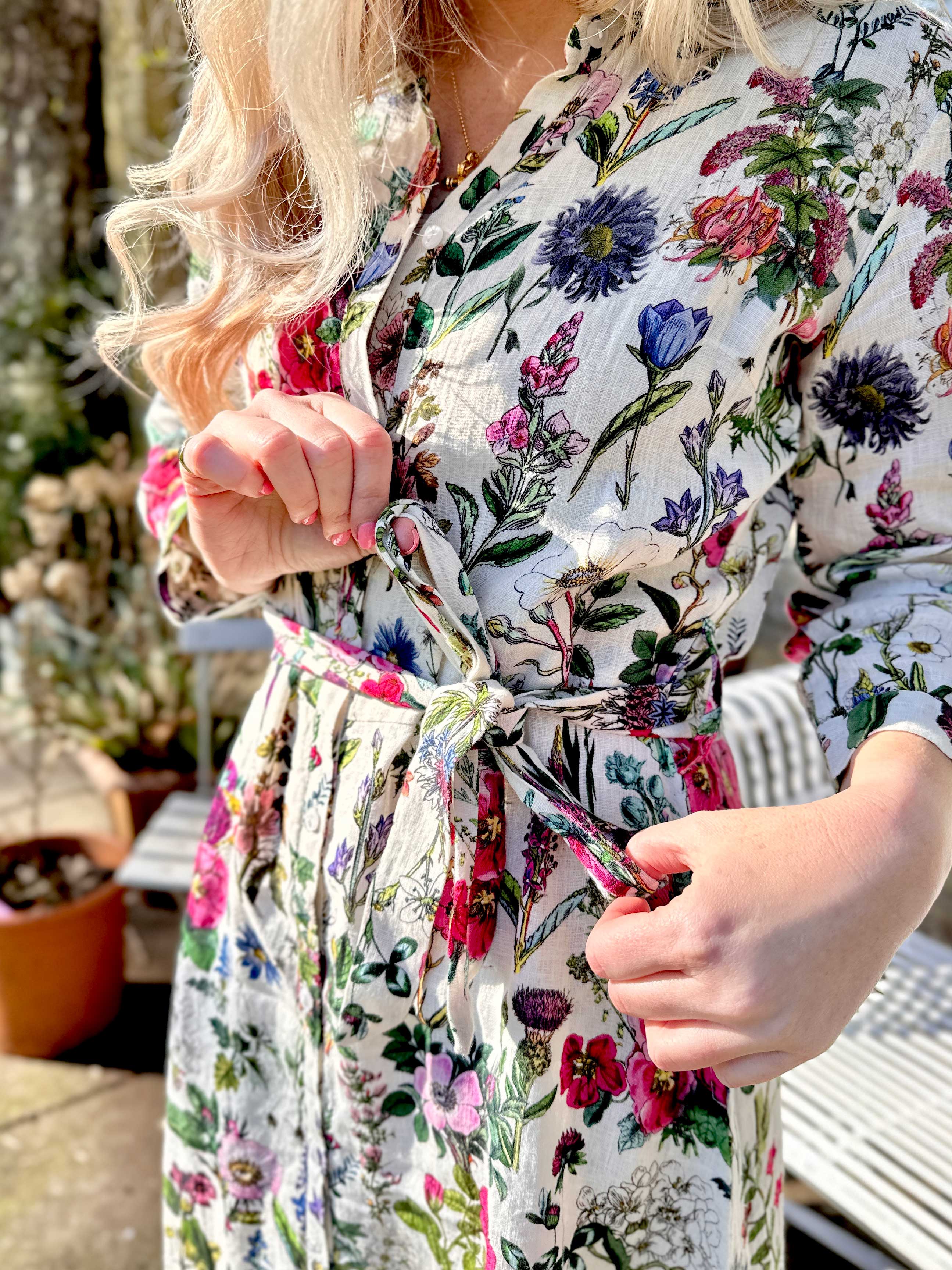 Spring into style with the Rosehip Design Lydia Linen Dress in Barcelona design. This shirt-waister dress features a beautiful floral design and a fabric tie belt for a flattering fit. With its long sleeves and button-up front, this dress is the perfect combination of comfort and chic. Ready to bloom in your wardrobe!