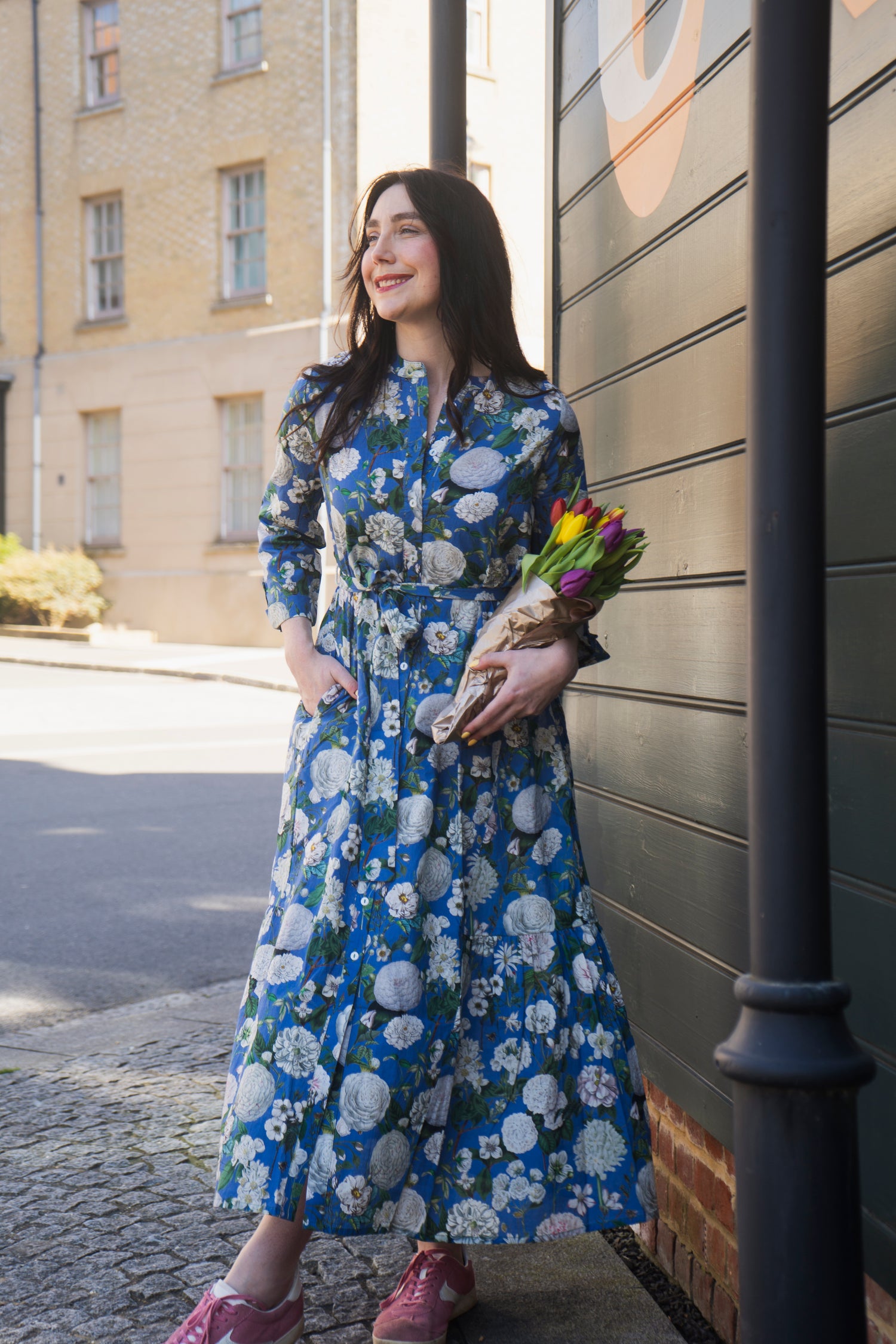 The Ally Cotton Dress in Camelia Periwinkle from Rosehip Design is a versatile wardrobe staple with effortless charm. Featuring a button-down front, handy pockets, and a flattering half-frill hem, it offers both style and comfort. Wear it loose for a relaxed feel or cinch the waist with the tie belt for a more defined silhouette—perfect for any occasion.