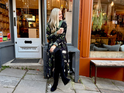 Wrap yourself in autumn warmth with this long velvet coat in a rich Rosehip Design Winter Floral that perfectly echoes the season. The beautiful plum tones on navy blue are perfect for this time of year. The soft velvet exterior is complemented by a classic check lining, adding a touch of style to its bold, modern silhouette. Luxuriously warm yet effortlessly wearable, it’s the perfect layer for crisp autumn days — whether you’re strolling through the countryside or heading into the city.