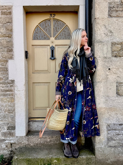 Wrap yourself in autumn warmth with this long velvet coat in a rich Rosehip Design Winter Floral that perfectly echoes the season. The beautiful plum tones on navy blue are perfect for this time of year. The soft velvet exterior is complemented by a classic check lining, adding a touch of style to its bold, modern silhouette. Luxuriously warm yet effortlessly wearable, it’s the perfect layer for crisp autumn days — whether you’re strolling through the countryside or heading into the city.