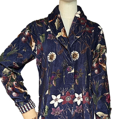 Wrap yourself in autumn warmth with this long velvet coat in a rich Rosehip Design Winter Floral that perfectly echoes the season. The beautiful plum tones on navy blue are perfect for this time of year. The soft velvet exterior is complemented by a classic check lining, adding a touch of style to its bold, modern silhouette. Luxuriously warm yet effortlessly wearable, it’s the perfect layer for crisp autumn days — whether you’re strolling through the countryside or heading into the city.