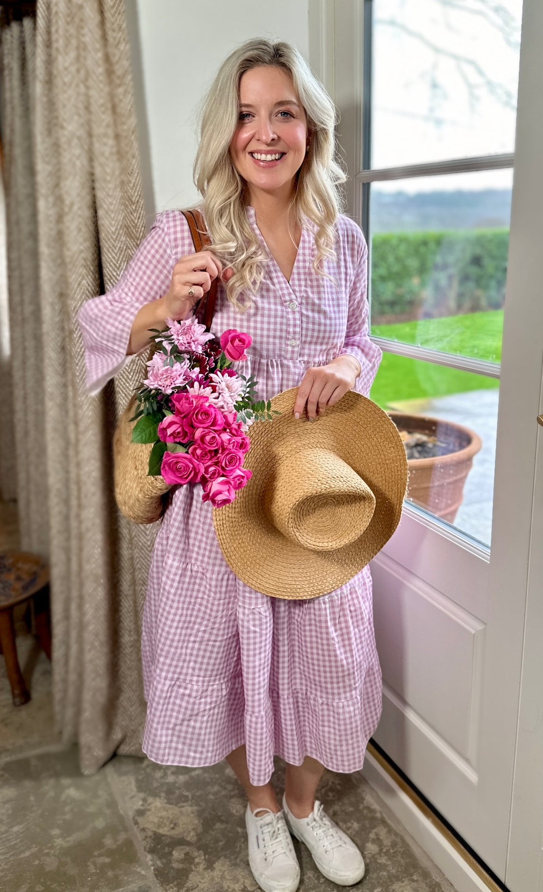 Rosehip Design Chloe Dress in Gingham Primrose is a classic summer floral tiered dress in a warm pink checked Gingham print with lovely long angel sleeves and side pockets, made from 100% soft Indian Cotton, packed in a matching bag.