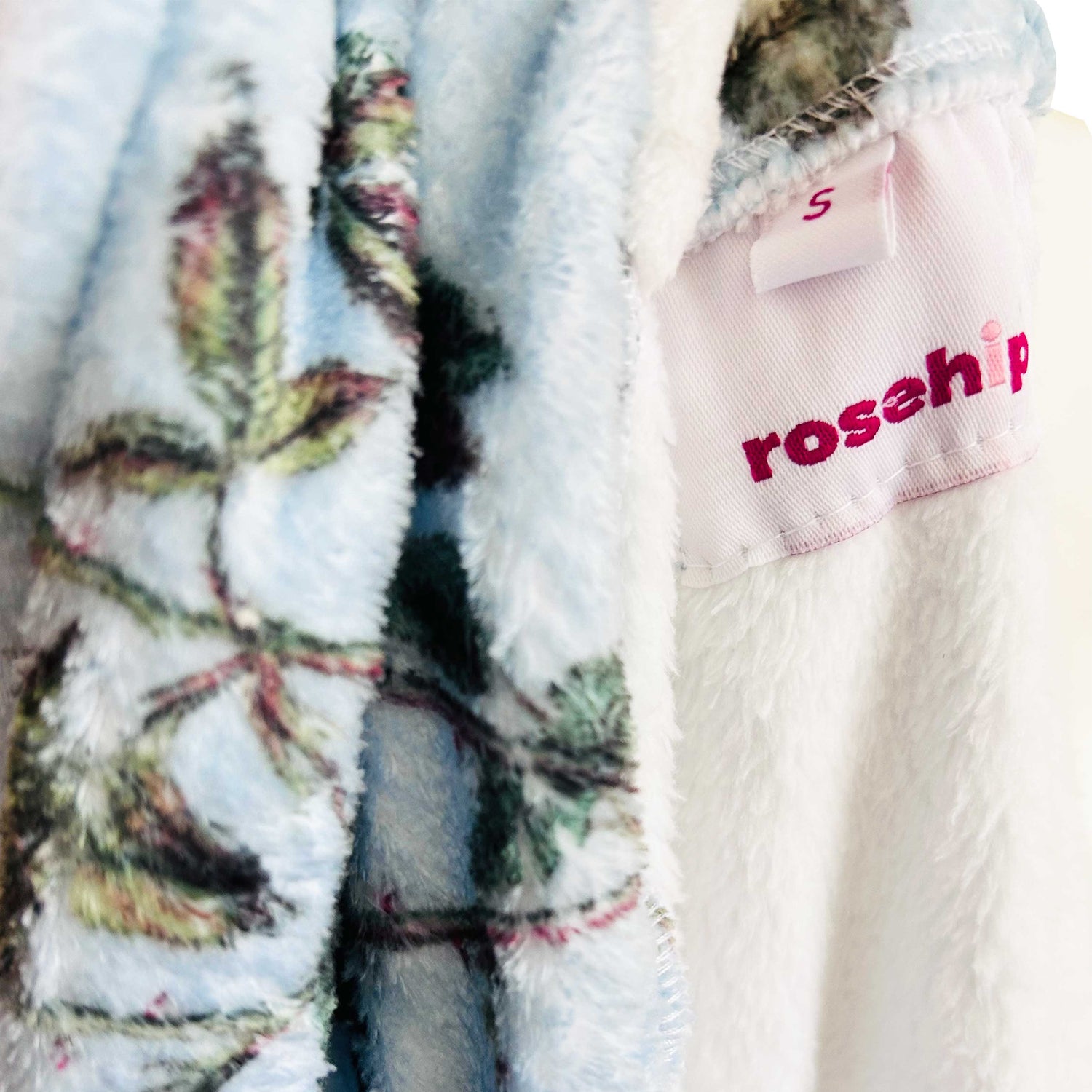 Rosehip Design Fleece Dressing Gown, the epitome of warmth and style for cozy winter evenings. A sumptuously soft dressing gown, designed to envelop you in a gentle embrace, offering a luxurious feel that is perfect for chilly nights. Crafted from high-quality fleece, this gown is not only exceptionally soft but also provides unparalleled comfort. The Heavenly Aqua design adds a touch of elegance with its delicate floral pattern, bringing a hint of nature&