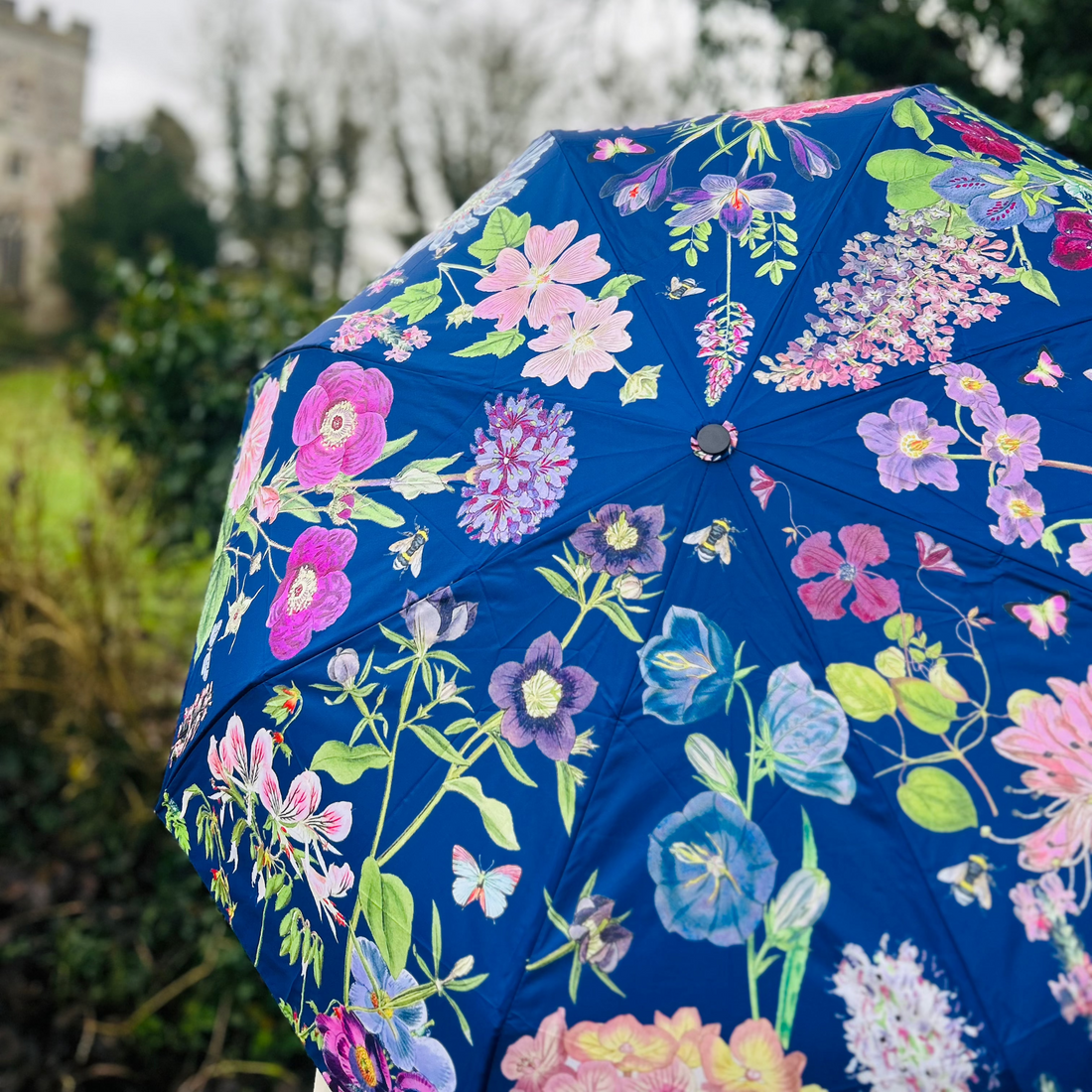 Rosehip Design Folding Umbrella is a sturdy, practical and waterproof rain umbrella with an auto pop-up button, perfectly sized for your car, bag or pocket. Be surrounded with floral joy in our magnificent Mallow Blues design.