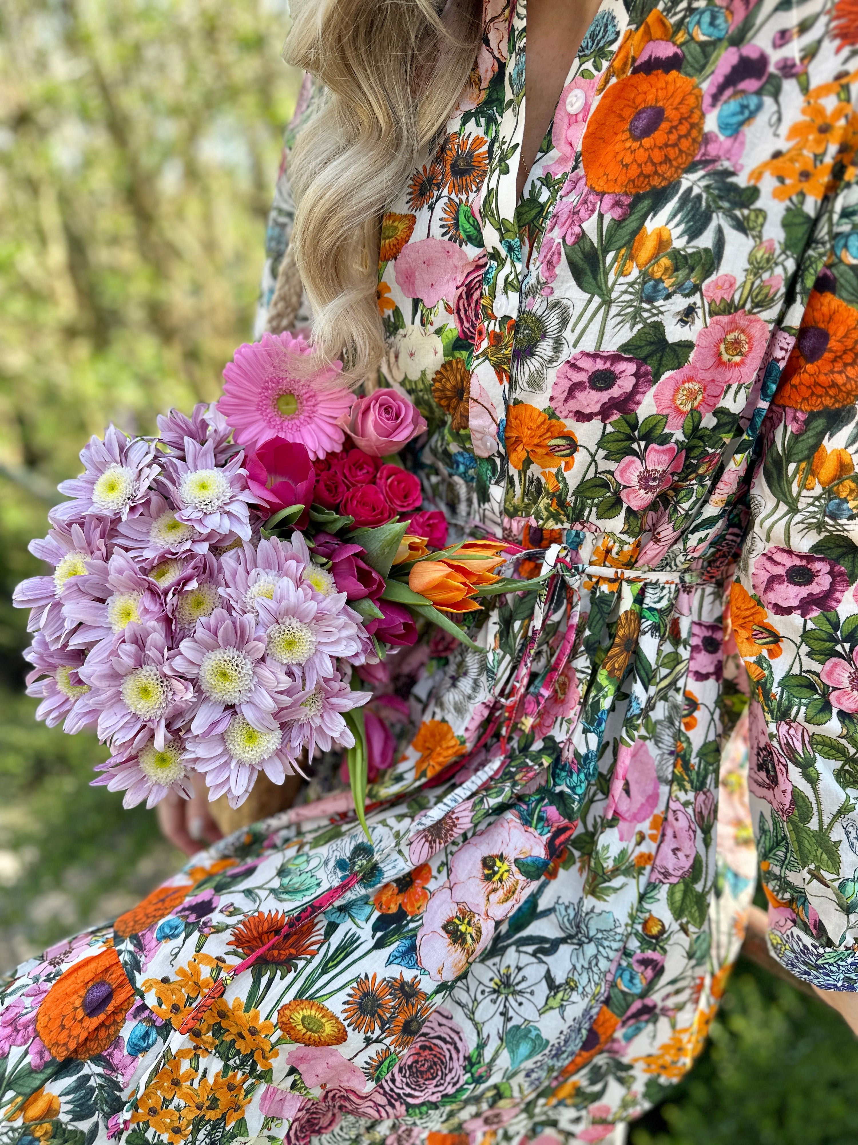 Easy, breezy and beautifully floral – the Rosehip Design Georgie Dress in our striking Fiesta print is made from soft, breathable cotton and designed with sunny days in mind. Featuring a fresh summery floral print, it has a relaxed tiered skirt, charming button-through front, and a detachable tie belt to style it your way. Wear it loose for an effortlessly laid-back look, or cinch it in for a more defined shape. Perfect for garden parties, picnics or simply soaking up the sunshine.
