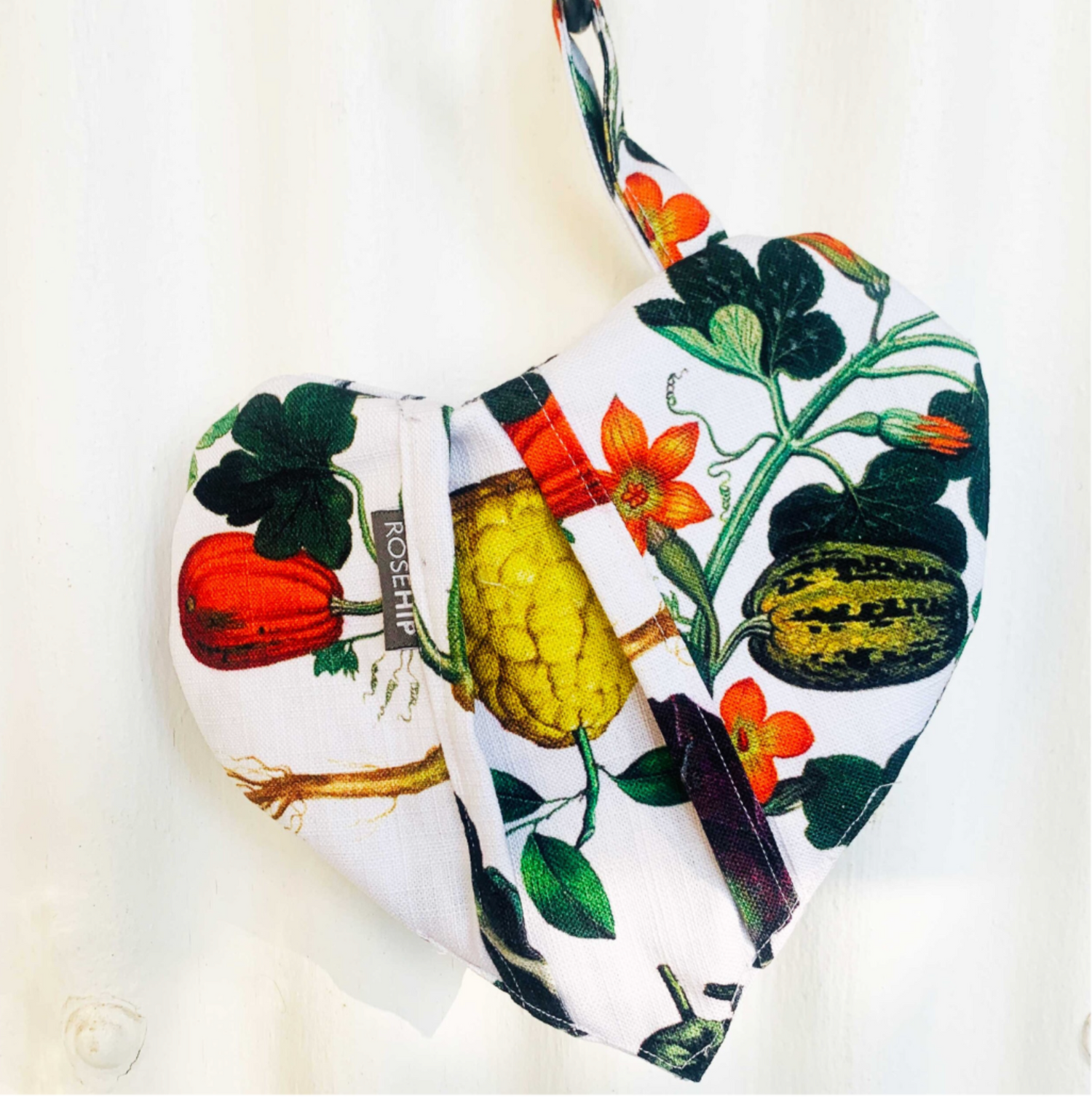 Rosehip Design Heart Potholder. A lovely heart shaped potholder/oven mitt in our almost edible Jardiniere design. Padded with loop to hang on a hook. Matching aprons available.