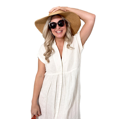 Rosehip Design Kate dress in White is a classic, staple essential for your wardrobe. It has hidden buttons down the front, short, capped sleeves, subtle pleats under the bust, curved side slits, and pockets. Made from 100% pure linen.