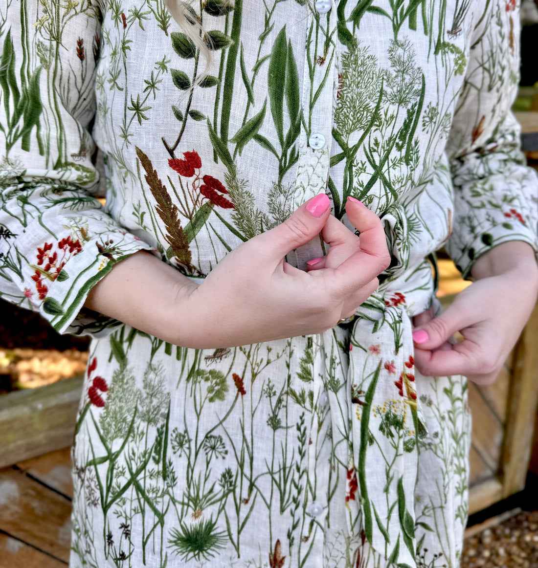 Spring into style with the Rosehip Design Lydia Linen Dress in Wildgrass design. This shirtwaister dress features a beautiful floral design and a fabric tie belt for a flattering fit. With its long sleeves and button-up front, this dress is the perfect combination of comfort and chic. Ready to bloom in your wardrobe!