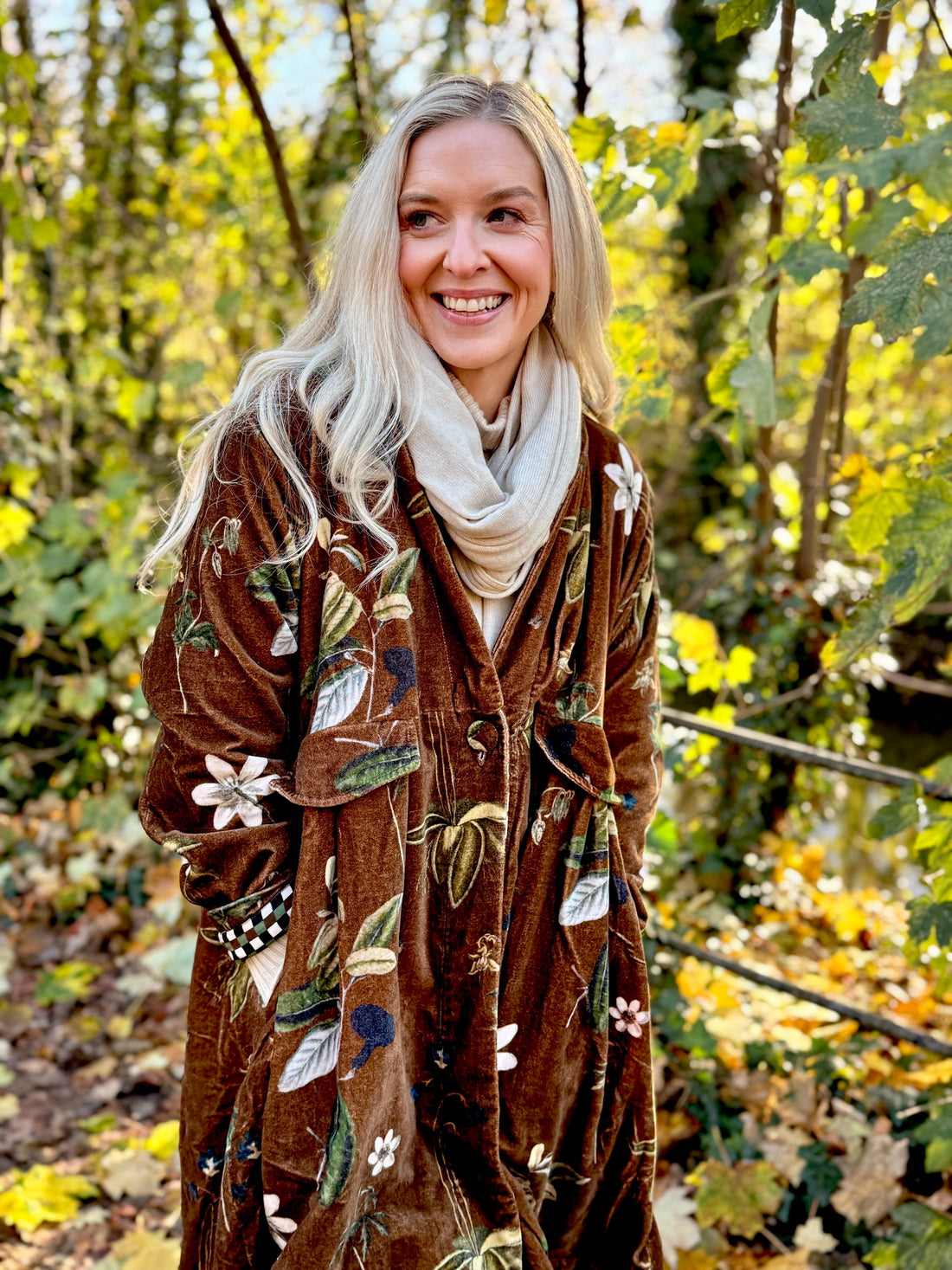 Wrap yourself in autumn warmth with this long velvet coat in a rich Rosehip Design Winter Floral that perfectly echoes the season. The soft velvet exterior is complemented by a classic check lining, adding a touch of style to its bold, modern silhouette. Luxuriously warm yet effortlessly wearable, it’s the perfect layer for crisp autumn days — whether you’re strolling through the countryside or heading into the city.
