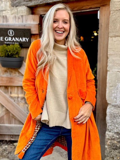 Wrap yourself in autumn warmth with this Rosehip Design statement velvet coat, in a rich, vibrant orange that perfectly echoes the season. The soft velvet exterior is complemented by a classic check lining, adding a touch of timeless style to its bold, modern silhouette. Luxuriously warm yet effortlessly wearable, it’s the perfect layer for crisp autumn days — whether you’re strolling through the countryside or heading into the city.