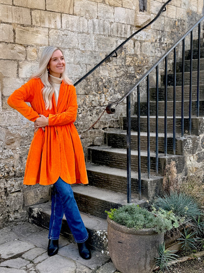 Wrap yourself in autumn warmth with this Rosehip Design statement velvet coat, in a rich, vibrant orange that perfectly echoes the season. The soft velvet exterior is complemented by a classic check lining, adding a touch of timeless style to its bold, modern silhouette. Luxuriously warm yet effortlessly wearable, it’s the perfect layer for crisp autumn days — whether you’re strolling through the countryside or heading into the city.